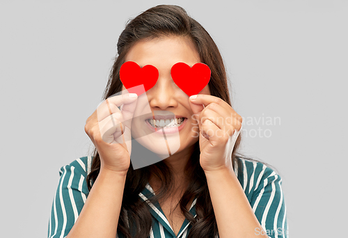 Image of happy asian woman covering her eyes with red heart