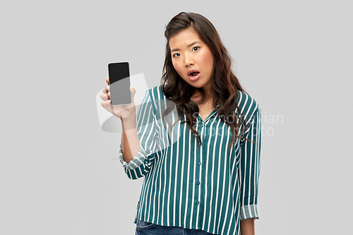 Image of shocked asian woman over grey background