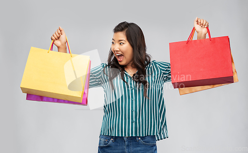 Image of happy asian woman with shopping bags