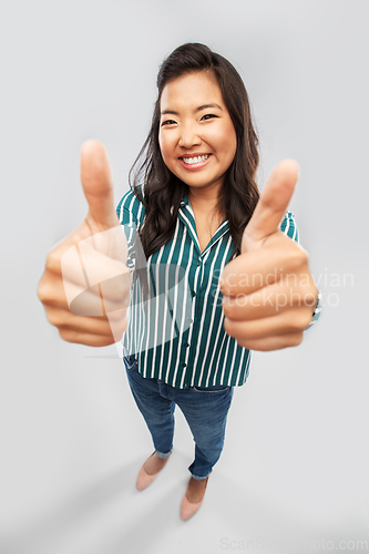 Image of happy smiling asian woman showing thumbs up