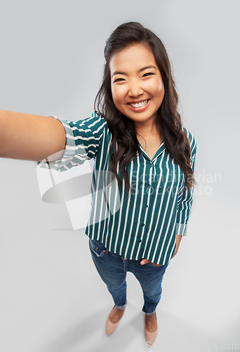 Image of happy smiling asian woman taking selfie