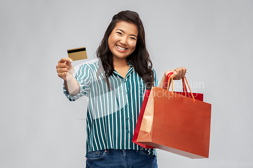 Image of asian woman with shopping bags and credit card