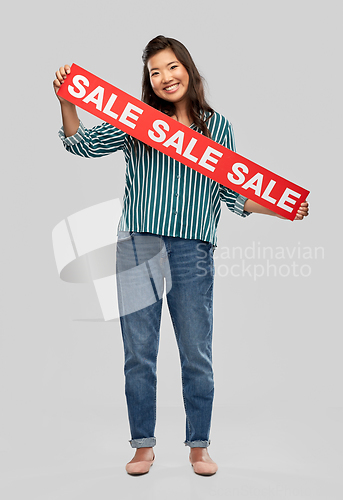 Image of happy smiling young asian woman with sale banner