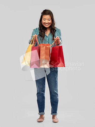 Image of happy asian woman with shopping bags