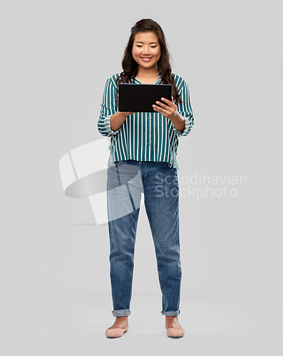 Image of happy asian woman using tablet computer