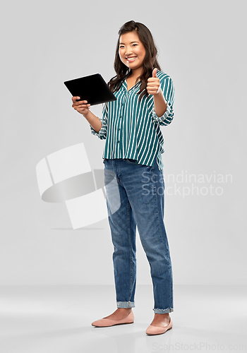 Image of happy asian woman with tablet pc showing thumbs up