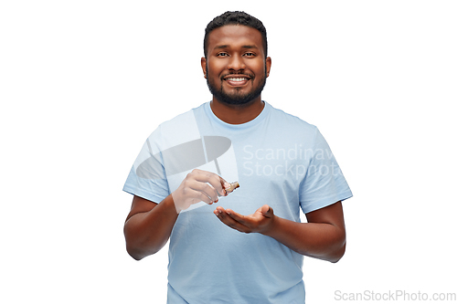 Image of african man applying grooming oil to beard