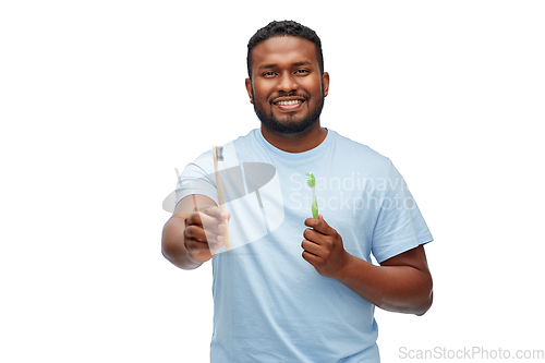 Image of african man with wooden and plastic toothbrushes