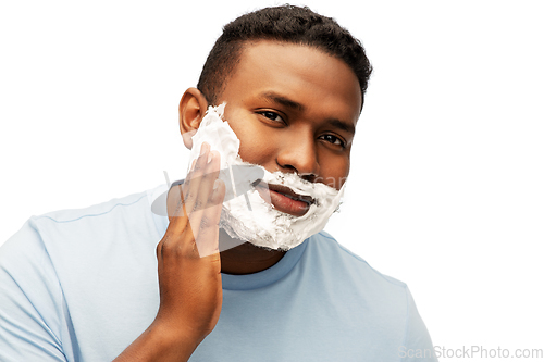 Image of african american man applying shaving foam to face