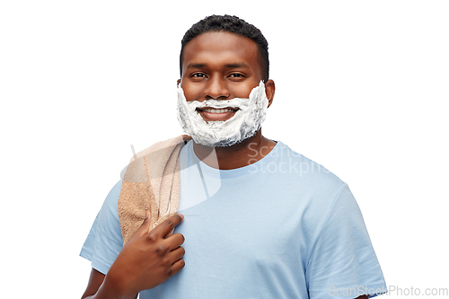 Image of smiling african man with shaving cream and towel