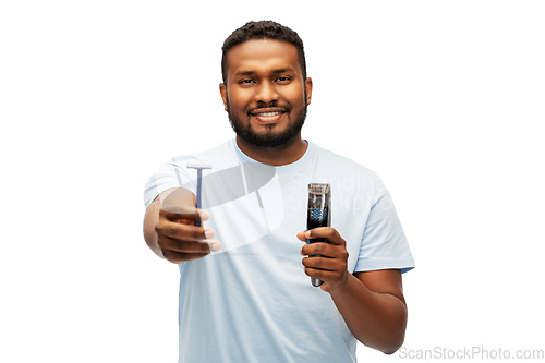 Image of smiling african man with razor blade and trimmer