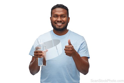 Image of happy african man with water in glass bottle