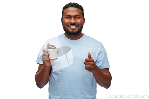 Image of african man with medicine showing thumbs up