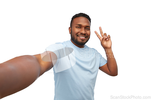 Image of smiling african american man taking selfie