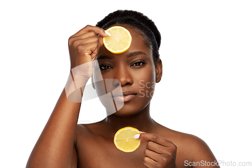 Image of african woman making eye mask of lemons