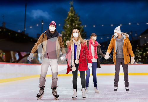 Image of friends in masks on christmas skating rink