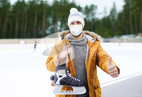 Image of man in mask showing thumbs up on skating rink