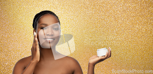 Image of smiling african american woman with moisturizer