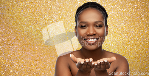 Image of happy african american woman holding something