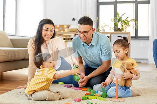 Image of happy family palying with wooden toys at home