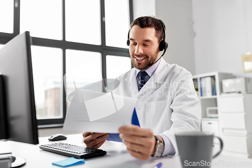 Image of happy doctor with computer and headset at hospital