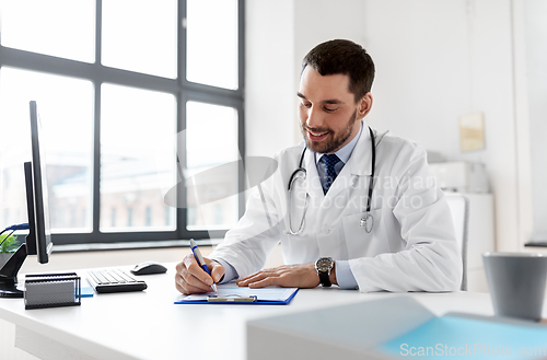 Image of smiling male doctor with clipboard at hospital