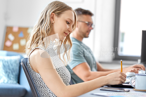 Image of businesswoman writing to notebook at office