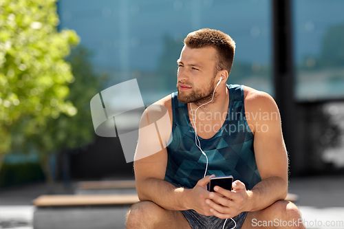 Image of young athlete man with earphones and smartphone