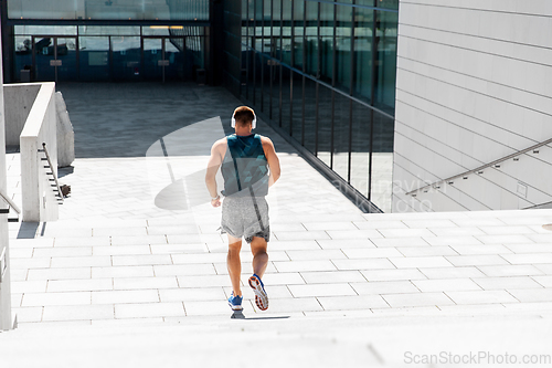 Image of young man in headphones running downstairs