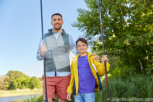 Image of happy smiling father and son fishing on river