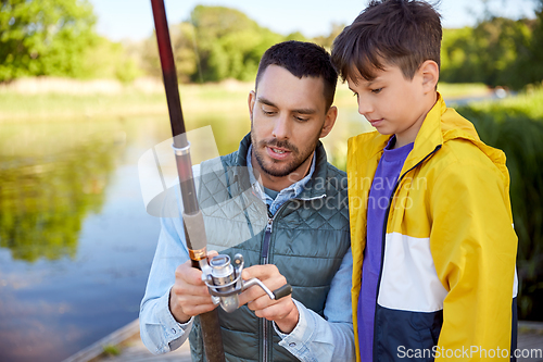 Image of father and son fishing on river