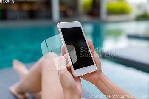 Image of Woman use of cellphone in swimming pool