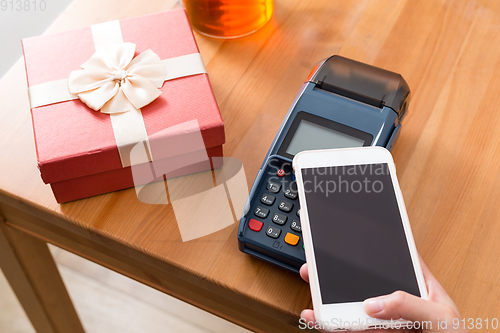 Image of Pay money on POS machine for buying gift