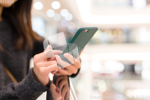 Image of Woman use of mobile phone in shopping mall