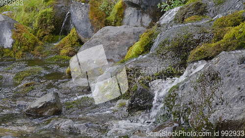 Image of Big beautiful waterfall flows down the rocks mountains