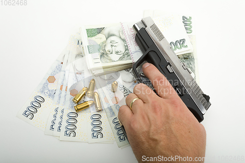 Image of gun and czech banknotes, crime concept