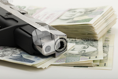 Image of gun and czech banknotes, crime concept