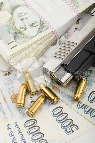 Image of gun and czech banknotes, crime concept