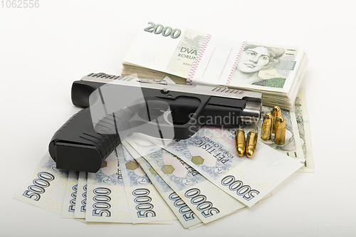 Image of gun and czech banknotes, crime concept