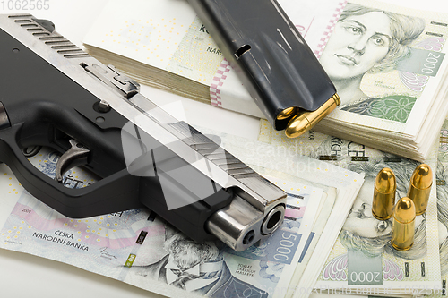 Image of gun and czech banknotes, crime concept