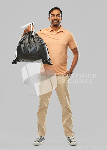 Image of smiling indian man holding trash bag