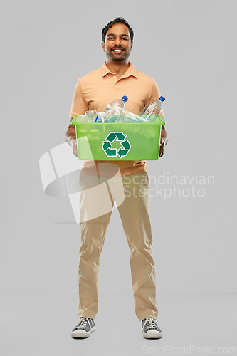 Image of smiling young indian man sorting plastic waste