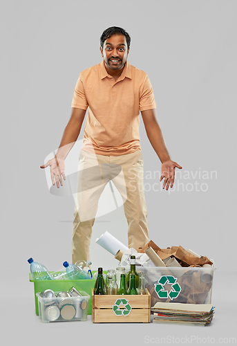 Image of smiling man sorting paper, glass and plastic waste