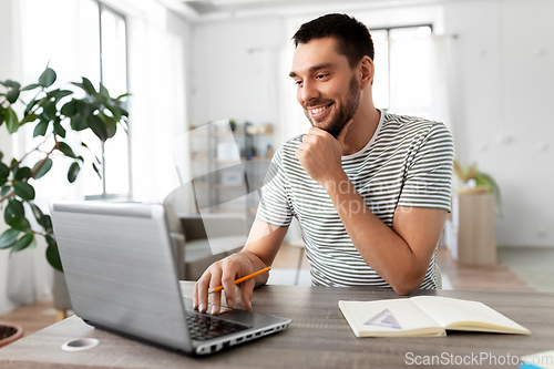 Image of man with laptop working at home office