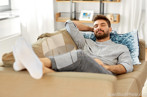 Image of young man sleeping on sofa at home