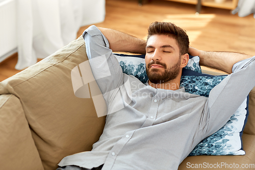 Image of young man sleeping on sofa at home