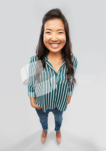Image of happy smiling asian woman over grey background