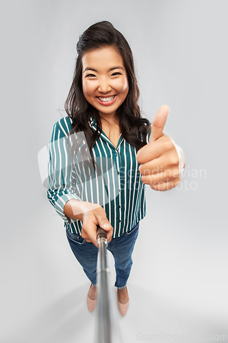 Image of asian woman taking selfie and showing thumbs up