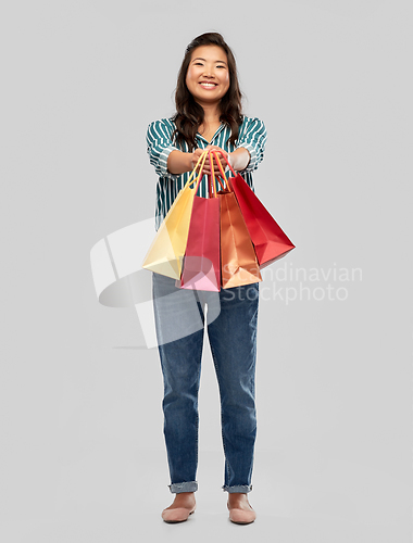 Image of happy asian woman with shopping bags