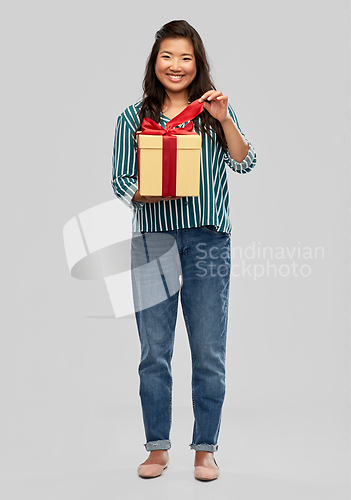 Image of happy asian woman opening gift box